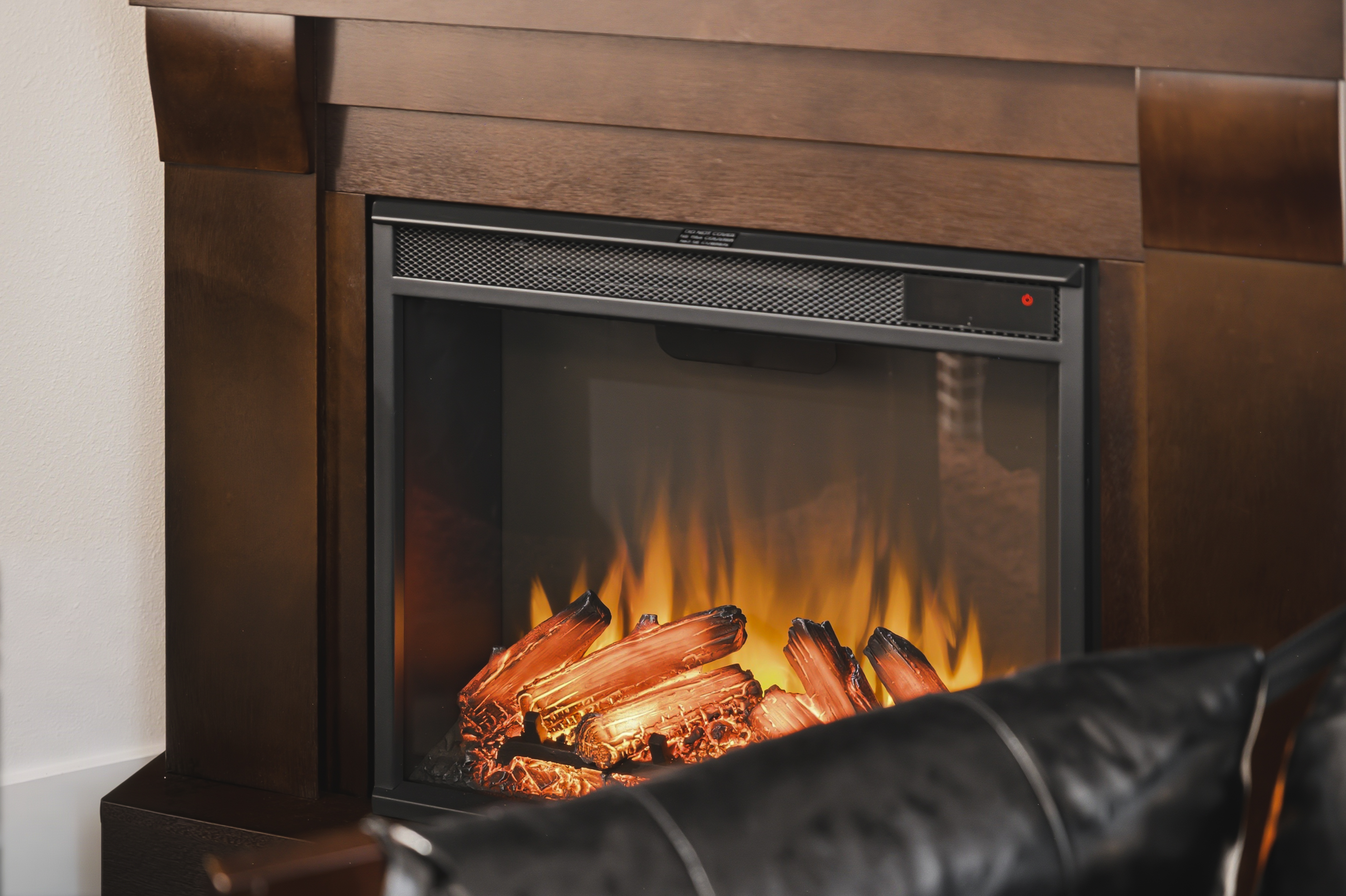 Electric fireplace burning in a timber surround