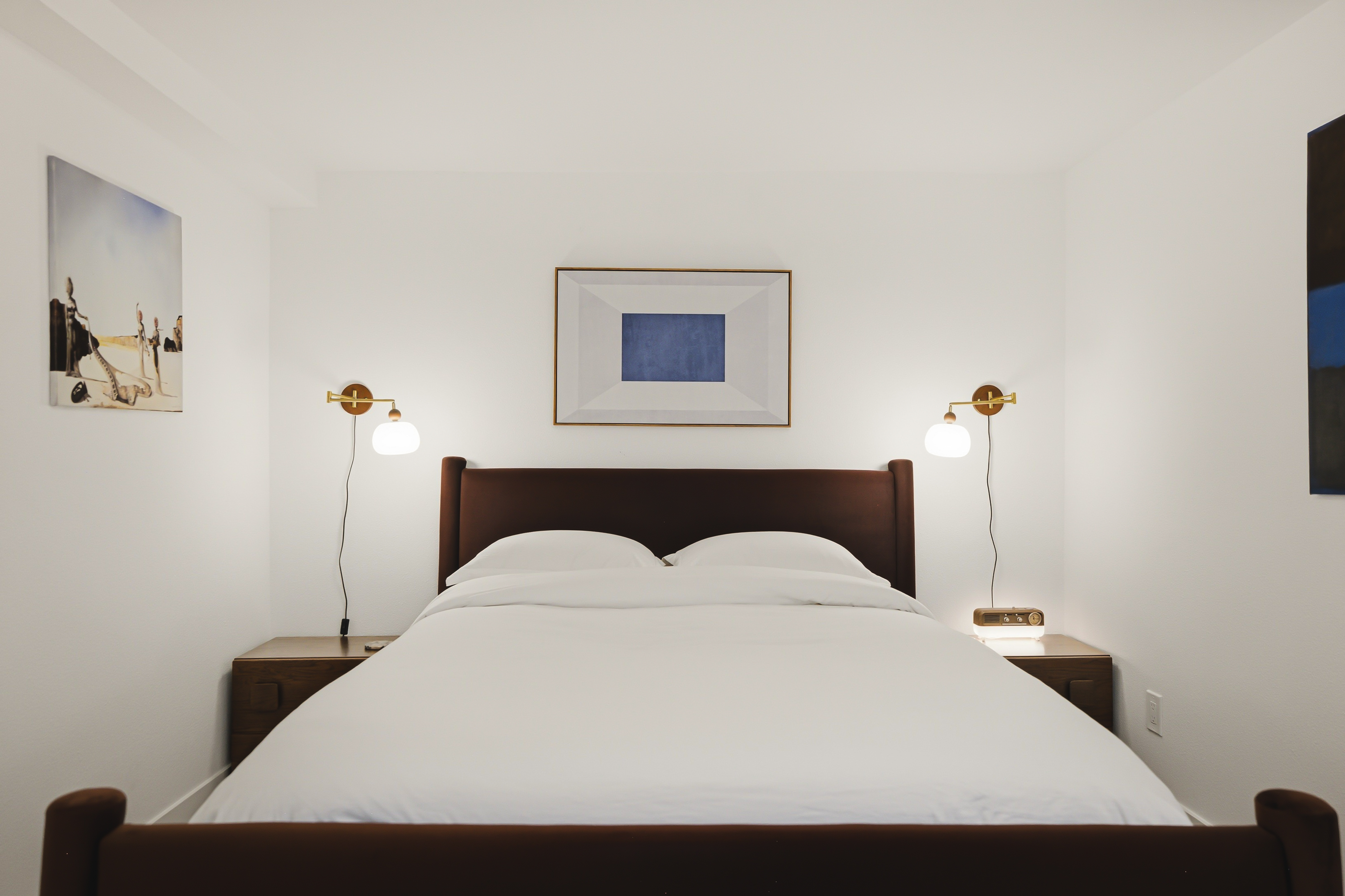 Bedroom with a wood headboard and a sconce on each side of the bed
