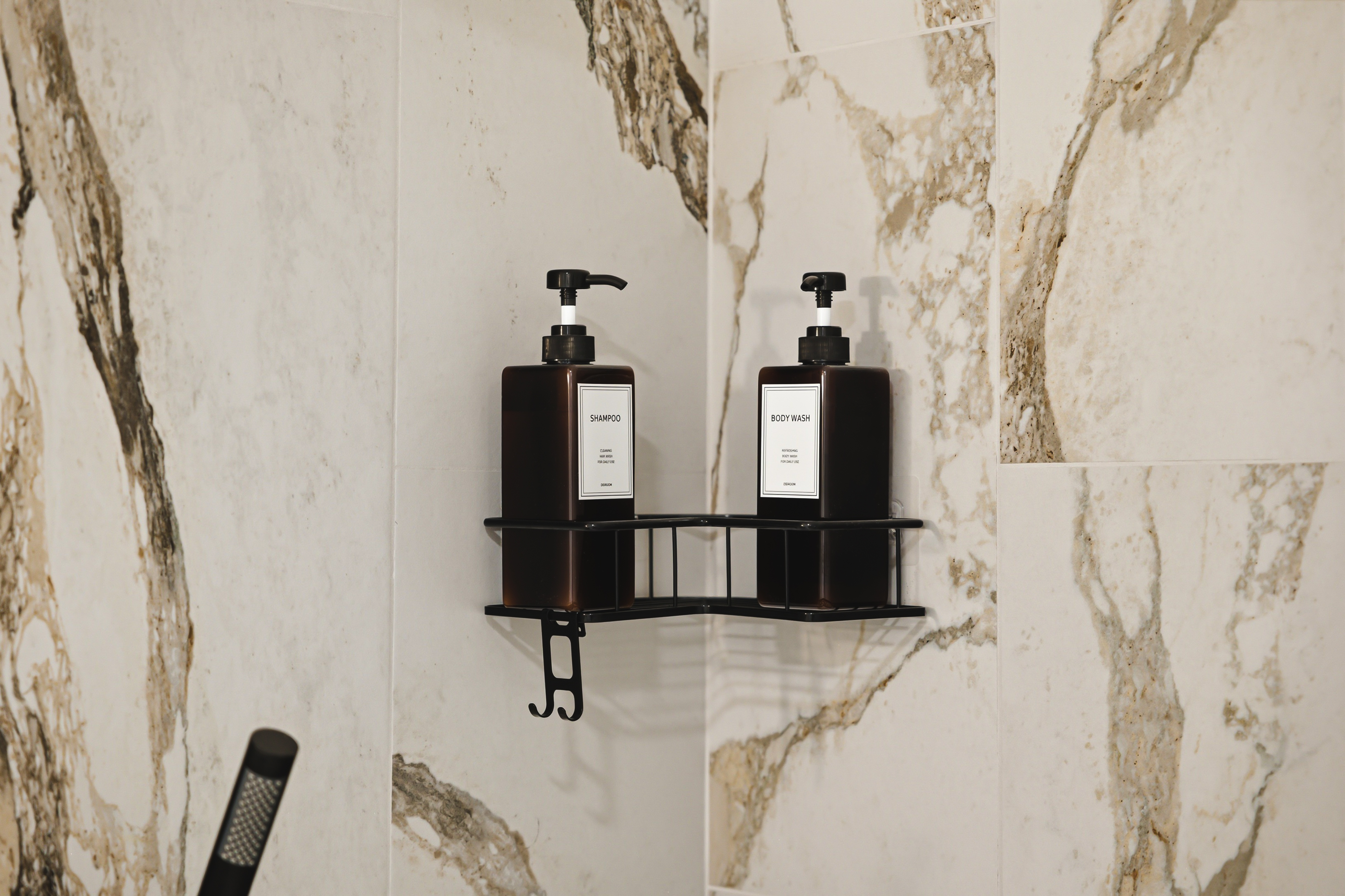Refillable shampoo and conditioner on a black shelf against the marble