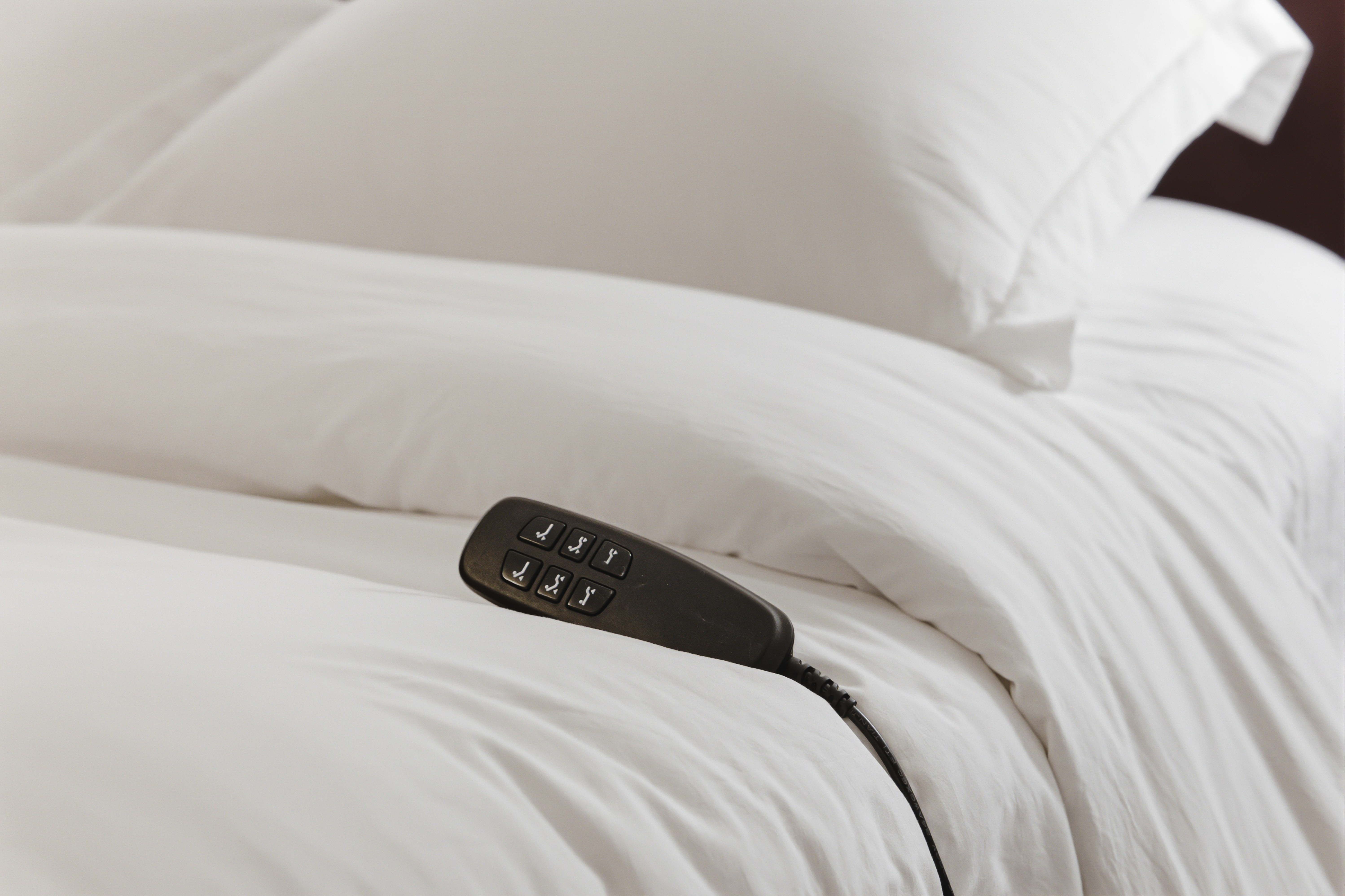Down duvet turned back with the adjustable bed remote resting on it