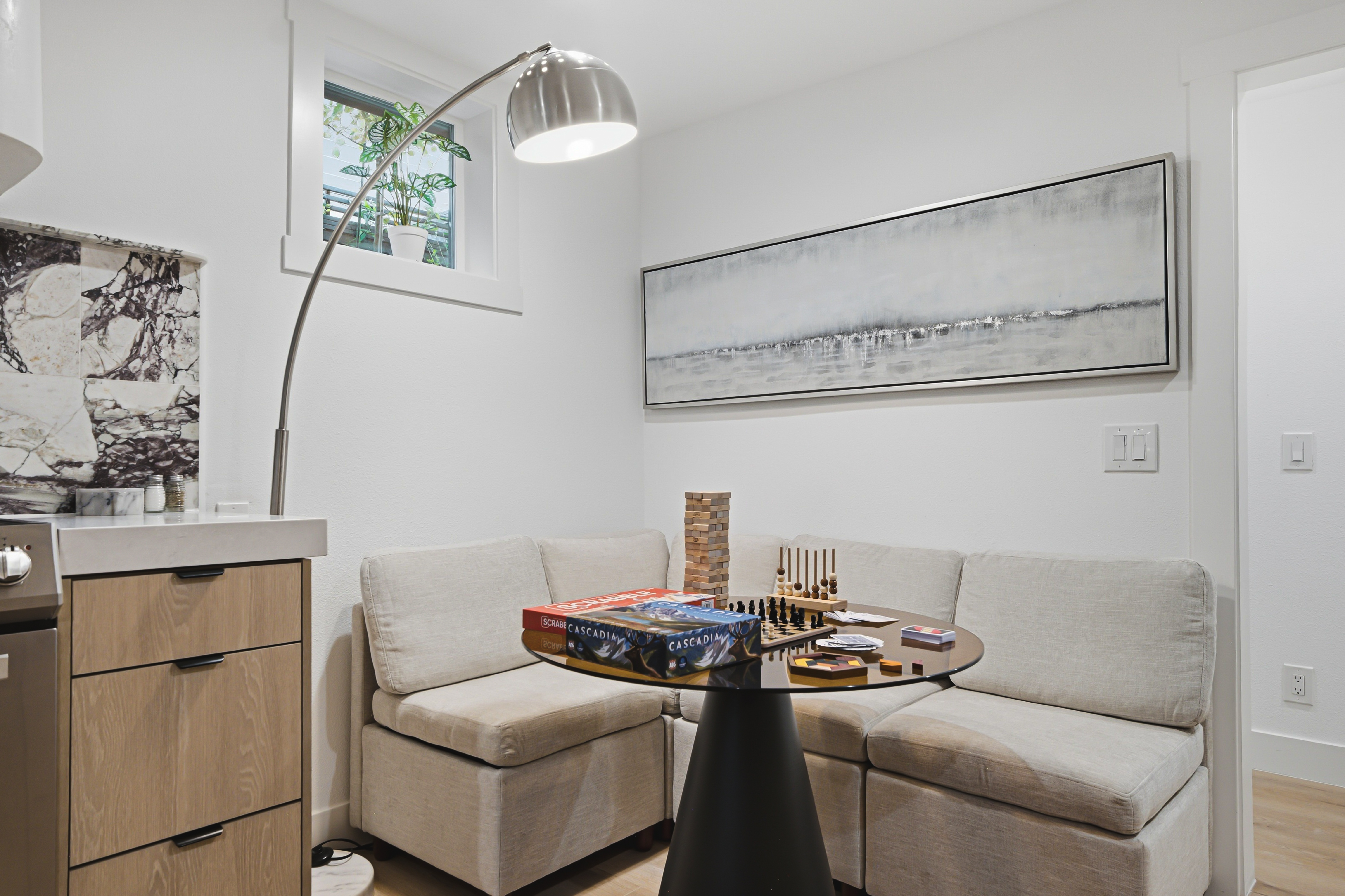Living room with a low sectional, arc lamp and a games table