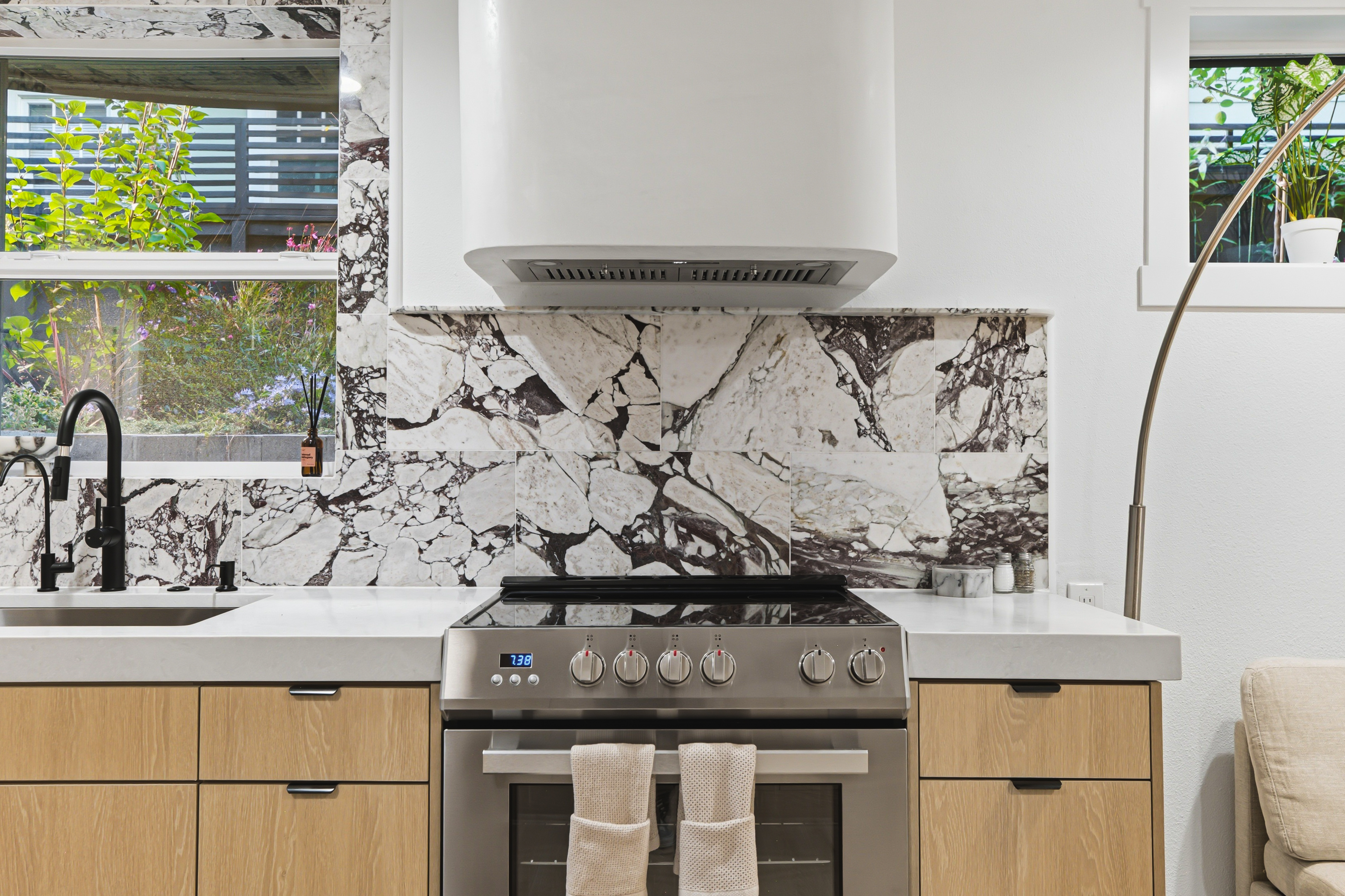 Range and vent hood set against the full height marble wall