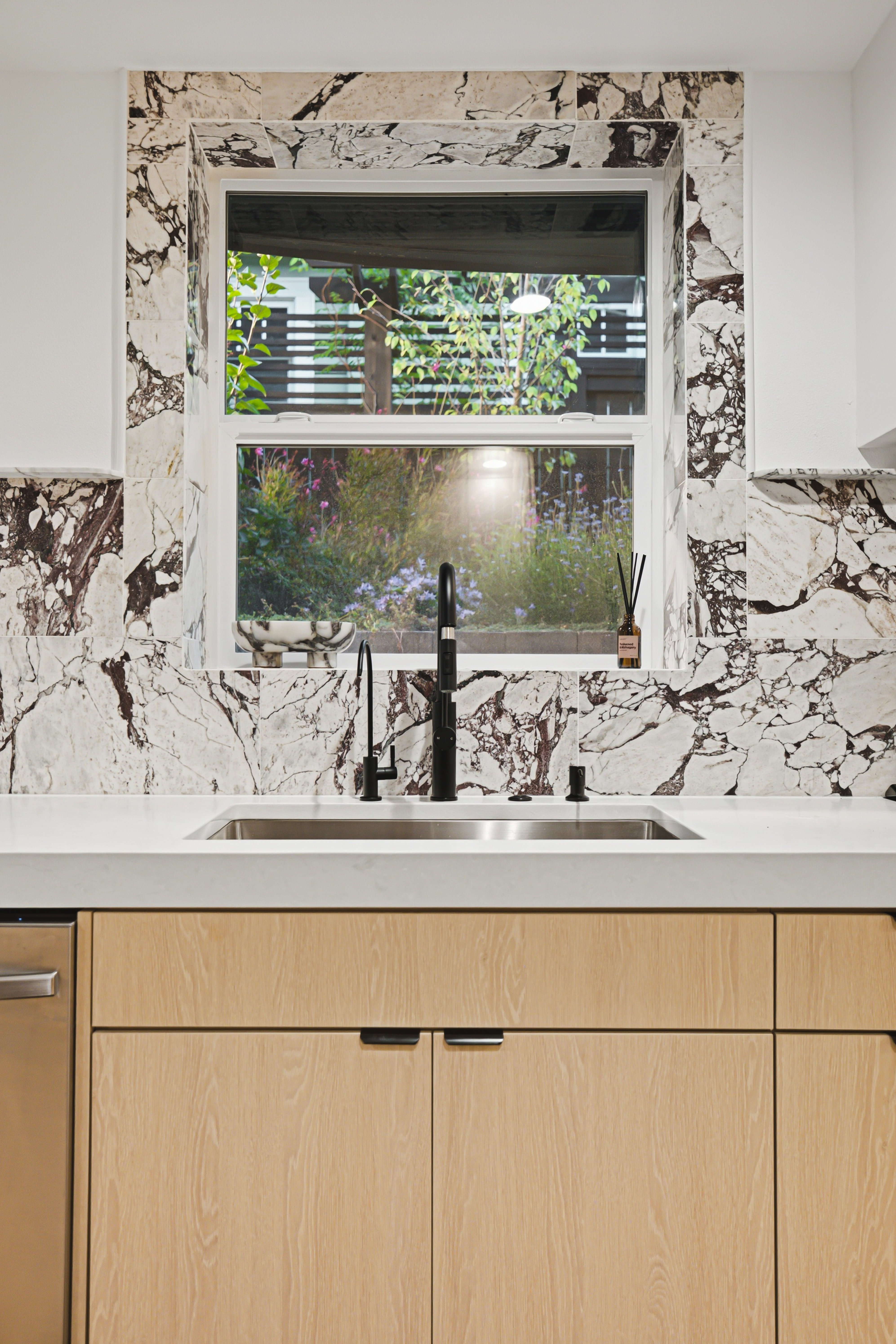 Undermount sink and black tap below the garden window